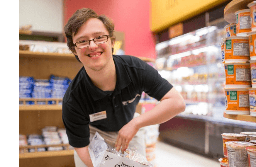 Image of a young man stocking the shelves in a grocery market.